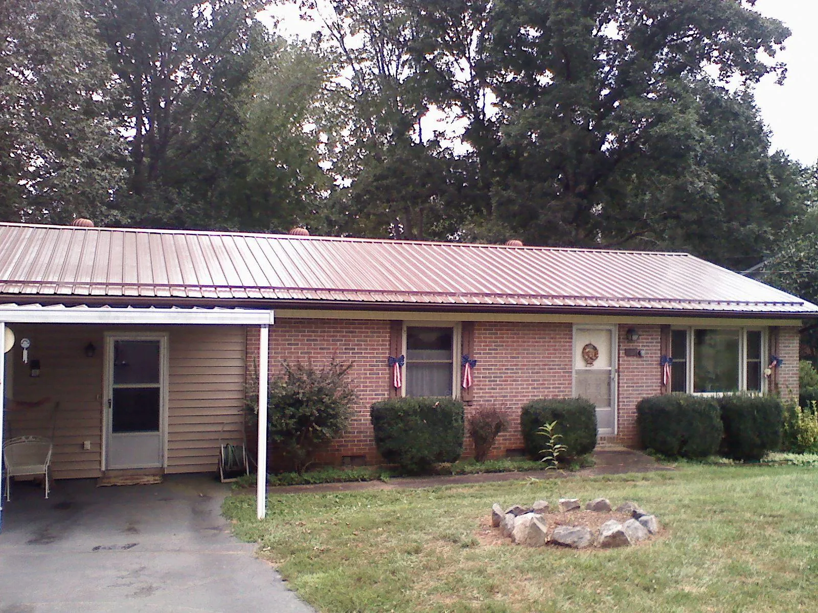 Bronze metal roof and carport on a brick ranch home — Roof Repair work by our crew in Highland Lake
